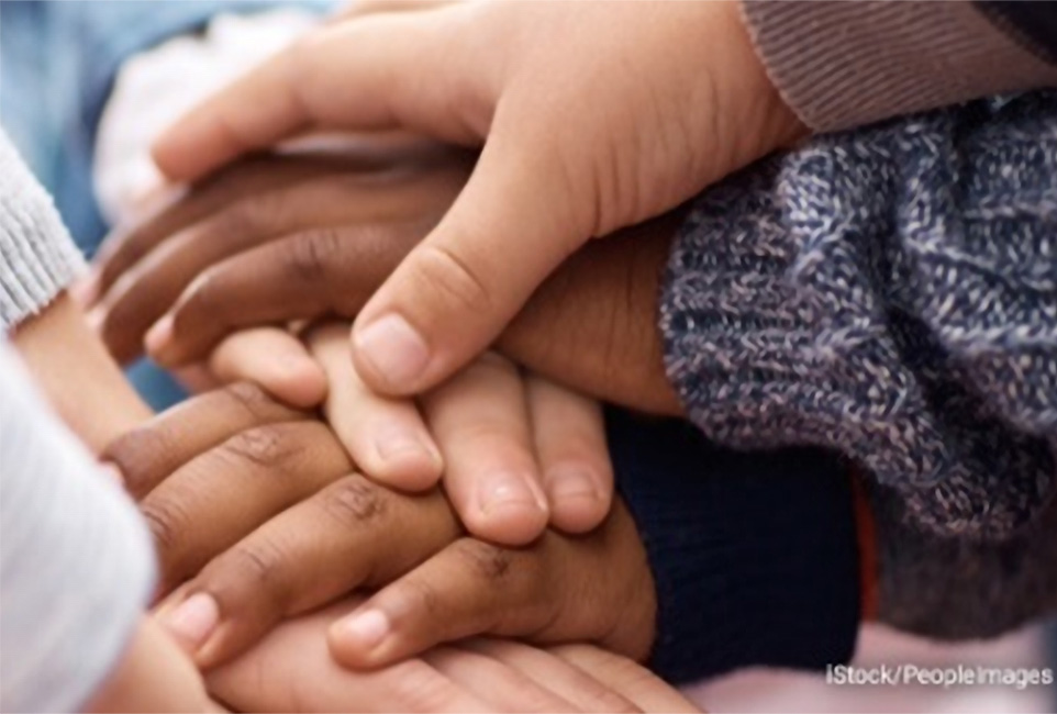 Stock photo of several children stacking their hands together