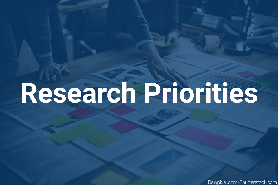 Research Priorities card People examining statistics laid out on a desk